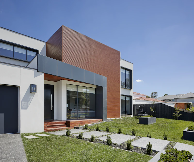 Moderner Hauseingang mit Holzpodest und Holzfassade