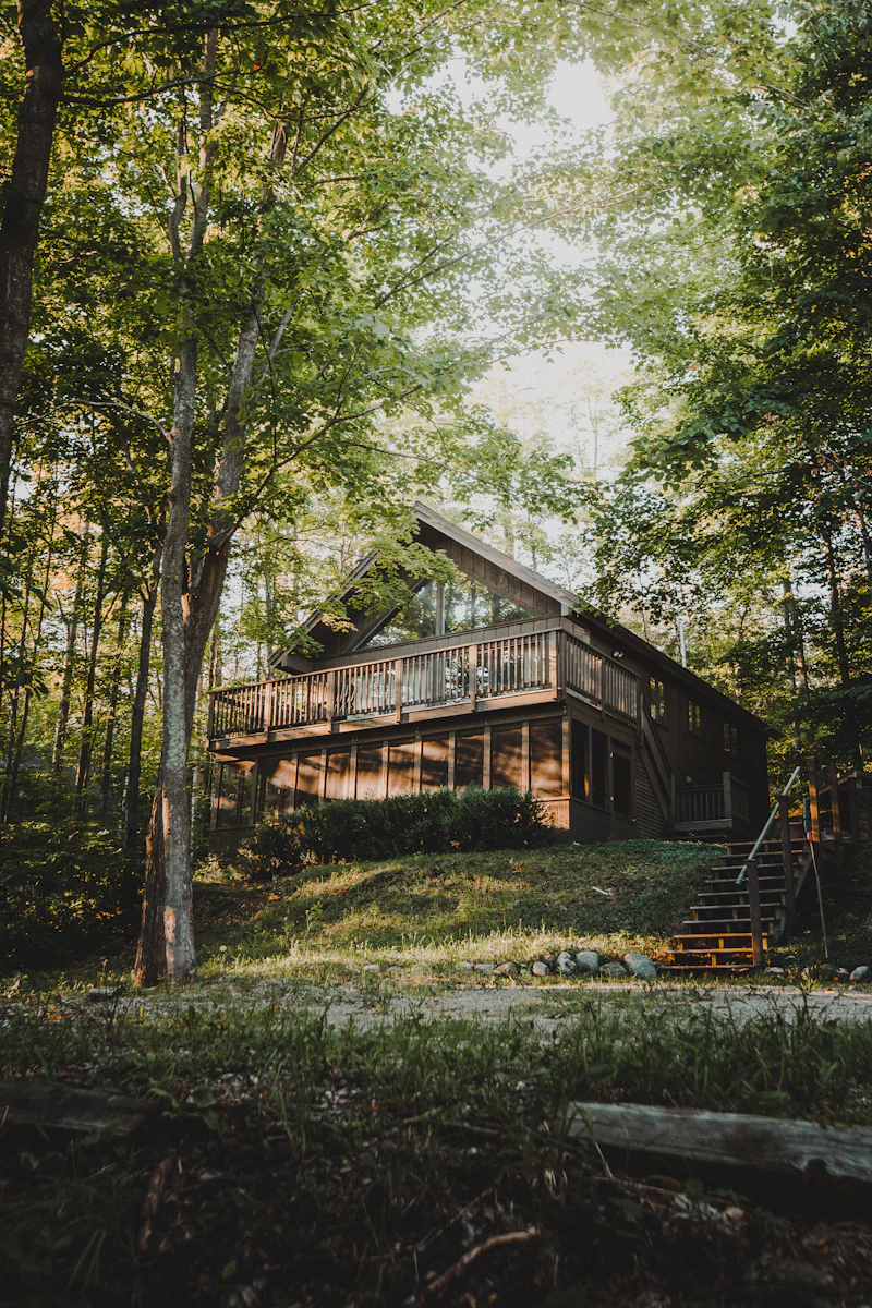 Holzdeck mit Geländer an einem Haus zwischen Bäumen